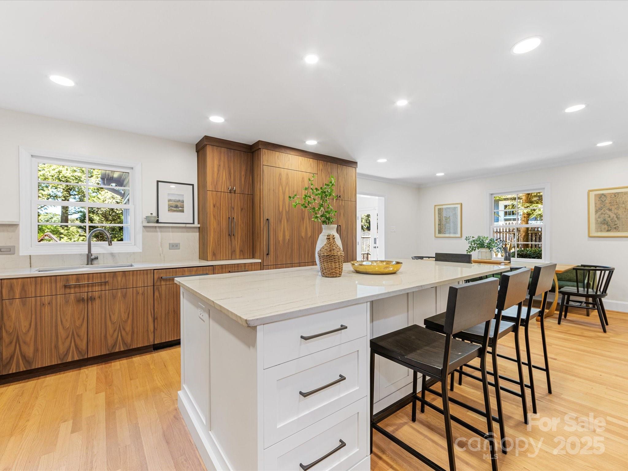 2118 Sharon Road Charlotte, NC 28207 - Photo 8 of 48 a kitchen with stainless steel appliances granite countertop wooden cabinets a stove a sink a dining table and chairs