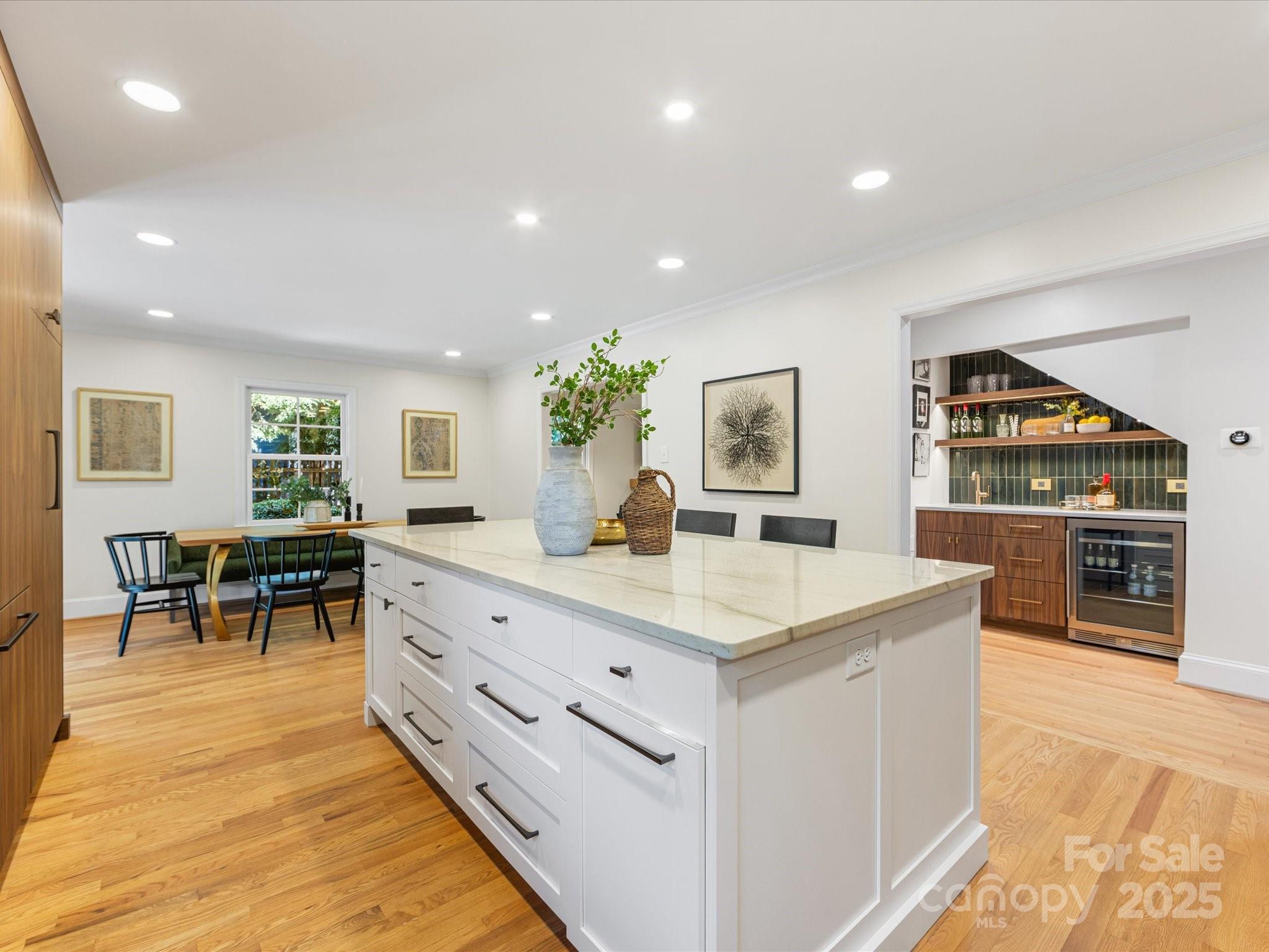 2118 Sharon Road Charlotte, NC 28207 - Photo 10 of 48 a large kitchen with stainless steel appliances a stove a sink a dining table and chairs with wooden floor