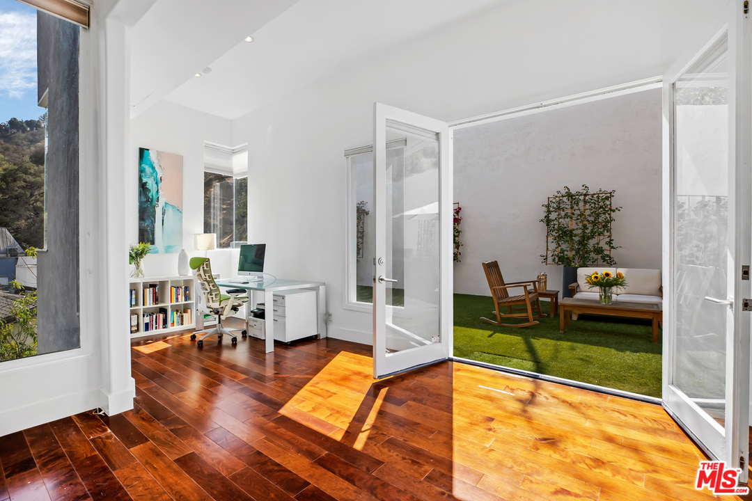 1857 North Beverly Drive Beverly Hills, CA 90210 - Photo 12 of 49 a living room with patio furniture and a floor to ceiling window