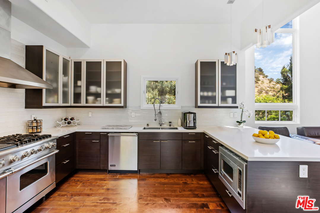 1857 North Beverly Drive Beverly Hills, CA 90210 - Photo 17 of 49 a kitchen that has a sink and a stove