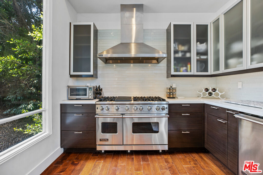 1857 North Beverly Drive Beverly Hills, CA 90210 - Photo 19 of 49 a kitchen with stainless steel appliances a stove a sink and a refrigerator