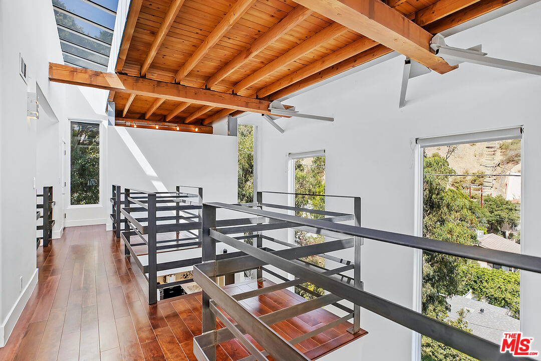 1857 North Beverly Drive Beverly Hills, CA 90210 - Photo 21 of 49 a view of a balcony with chairs and wooden floor