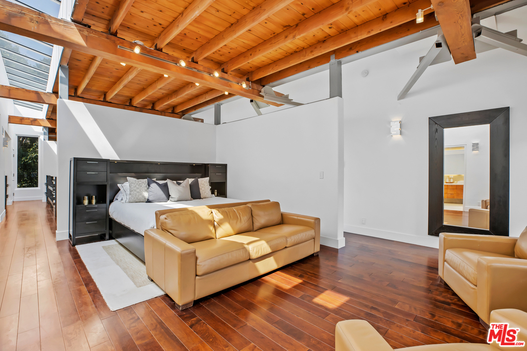 1857 North Beverly Drive Beverly Hills, CA 90210 - Photo 22 of 49 a bedroom with a bed and a couch