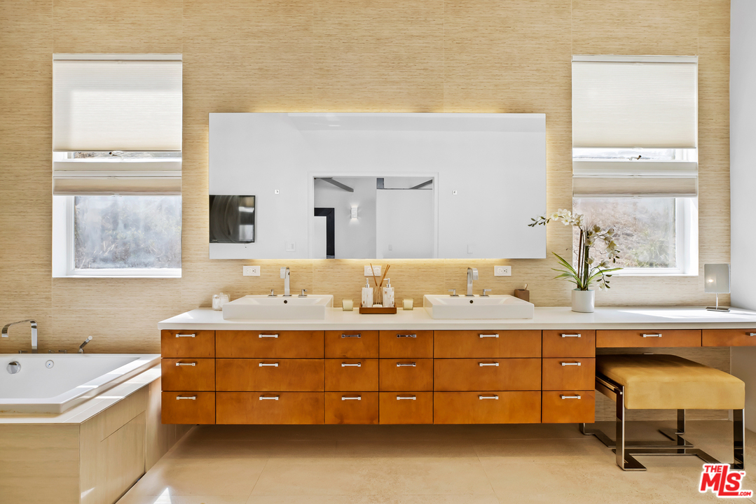 1857 North Beverly Drive Beverly Hills, CA 90210 - Photo 25 of 49 a bathroom with a tub sink and mirror