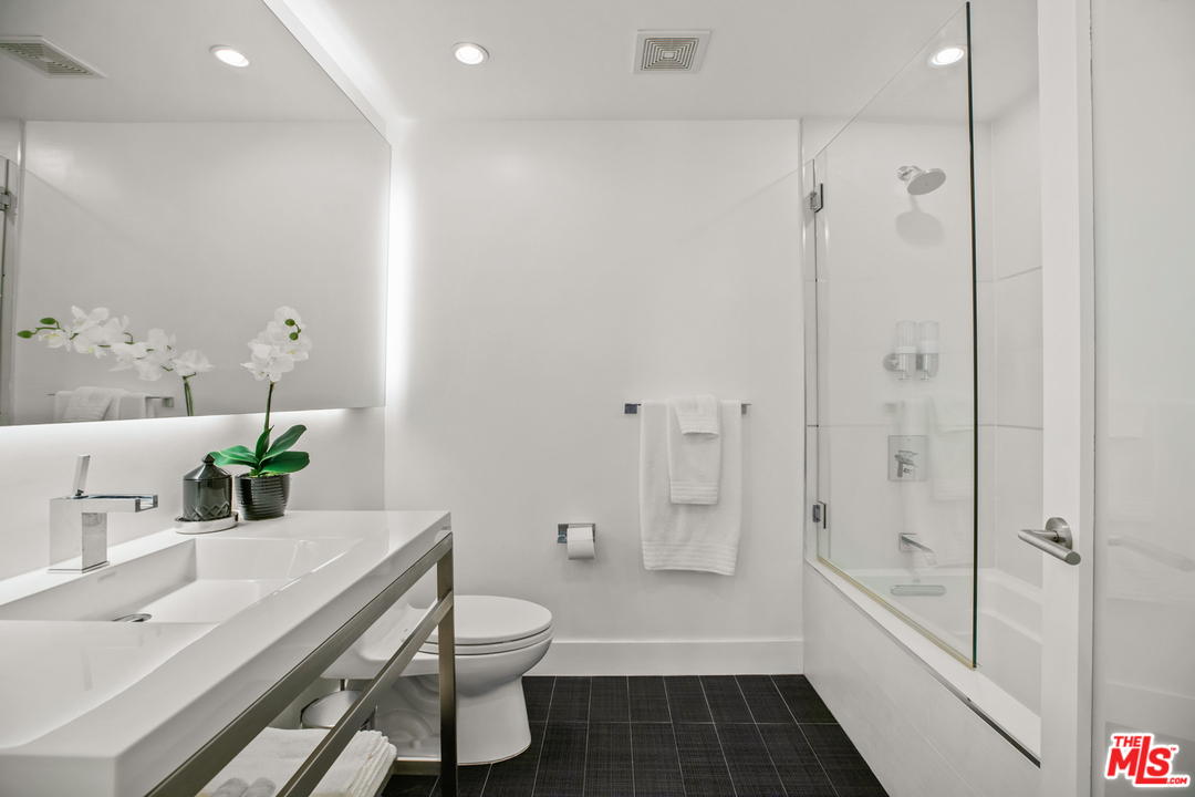 1857 North Beverly Drive Beverly Hills, CA 90210 - Photo 32 of 49 a bathroom with a bathtub shower sink and toilet