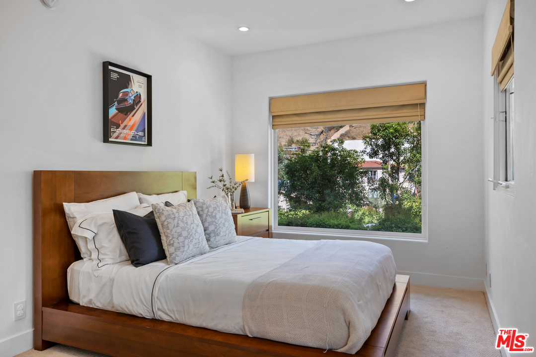 1857 North Beverly Drive Beverly Hills, CA 90210 - Photo 33 of 49 a bedroom with a large bed and a window