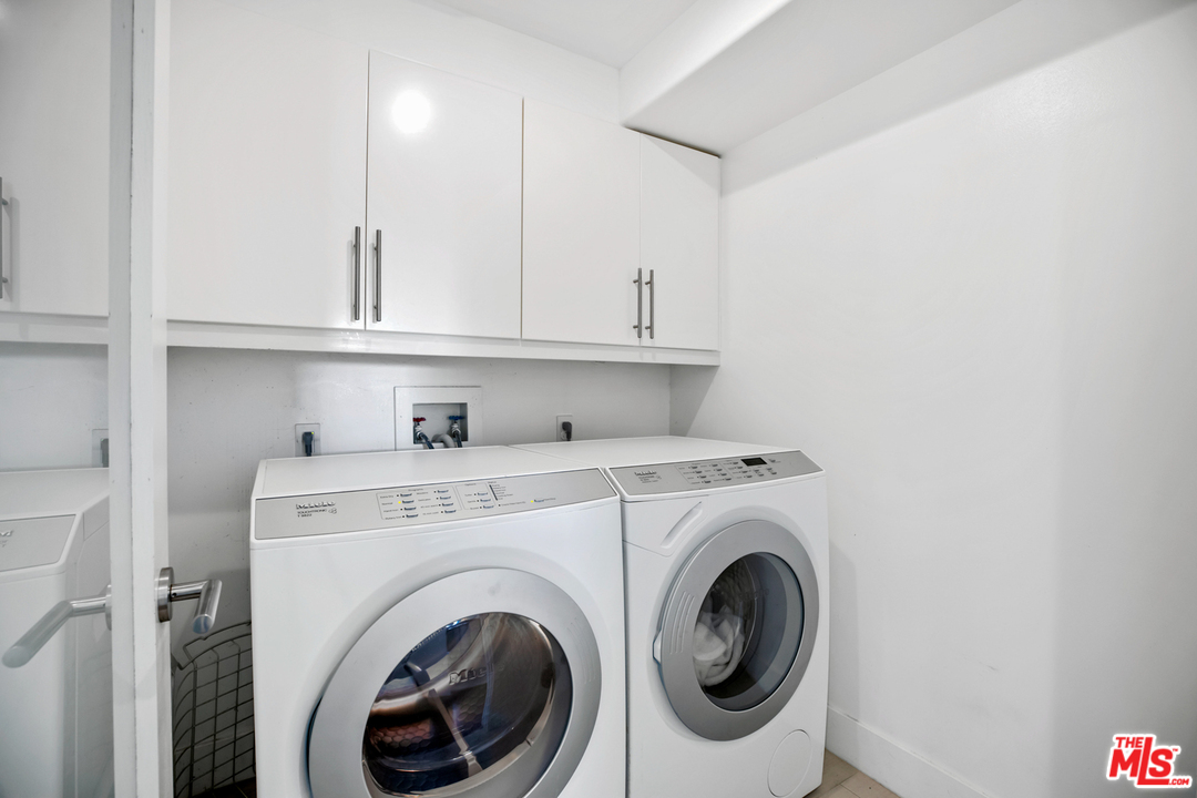 1857 North Beverly Drive Beverly Hills, CA 90210 - Photo 40 of 49 a view of washer and dryer with kitchen in the background