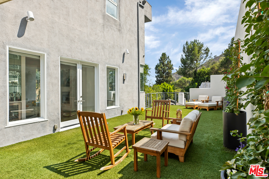 1857 North Beverly Drive Beverly Hills, CA 90210 - Photo 43 of 49 a view of a patio with table and chairs potted plants and large tree