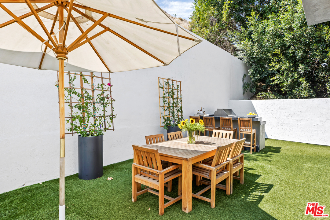 1857 North Beverly Drive Beverly Hills, CA 90210 - Photo 46 of 49 a dining room with furniture and garden