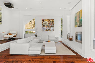1857 North Beverly Drive Beverly Hills, CA 90210 - Photo 8 of 49 a living room with furniture and a fireplace