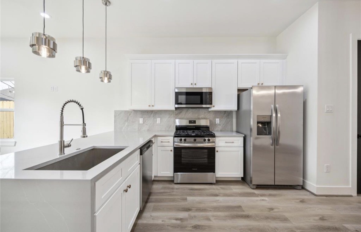 7980 Angus Street, Unit A Houston, TX 77028 - Photo 2 of 15 a kitchen with stainless steel appliances granite countertop a sink a stove a refrigerator and cabinets