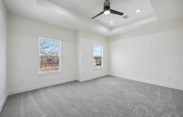 an empty room with a window and ceiling fan