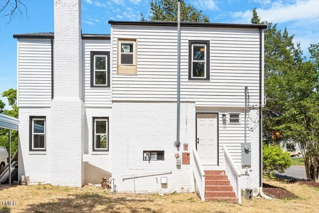 a front view of a house with a tree