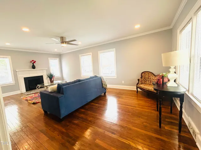 a living room with furniture a fireplace and a large window