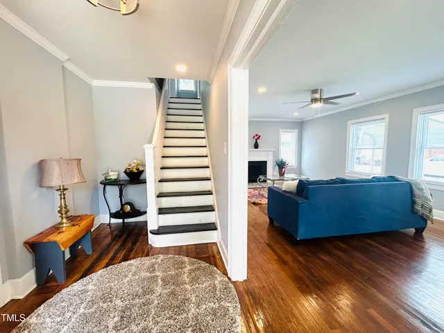 a living room with furniture and a wooden floor
