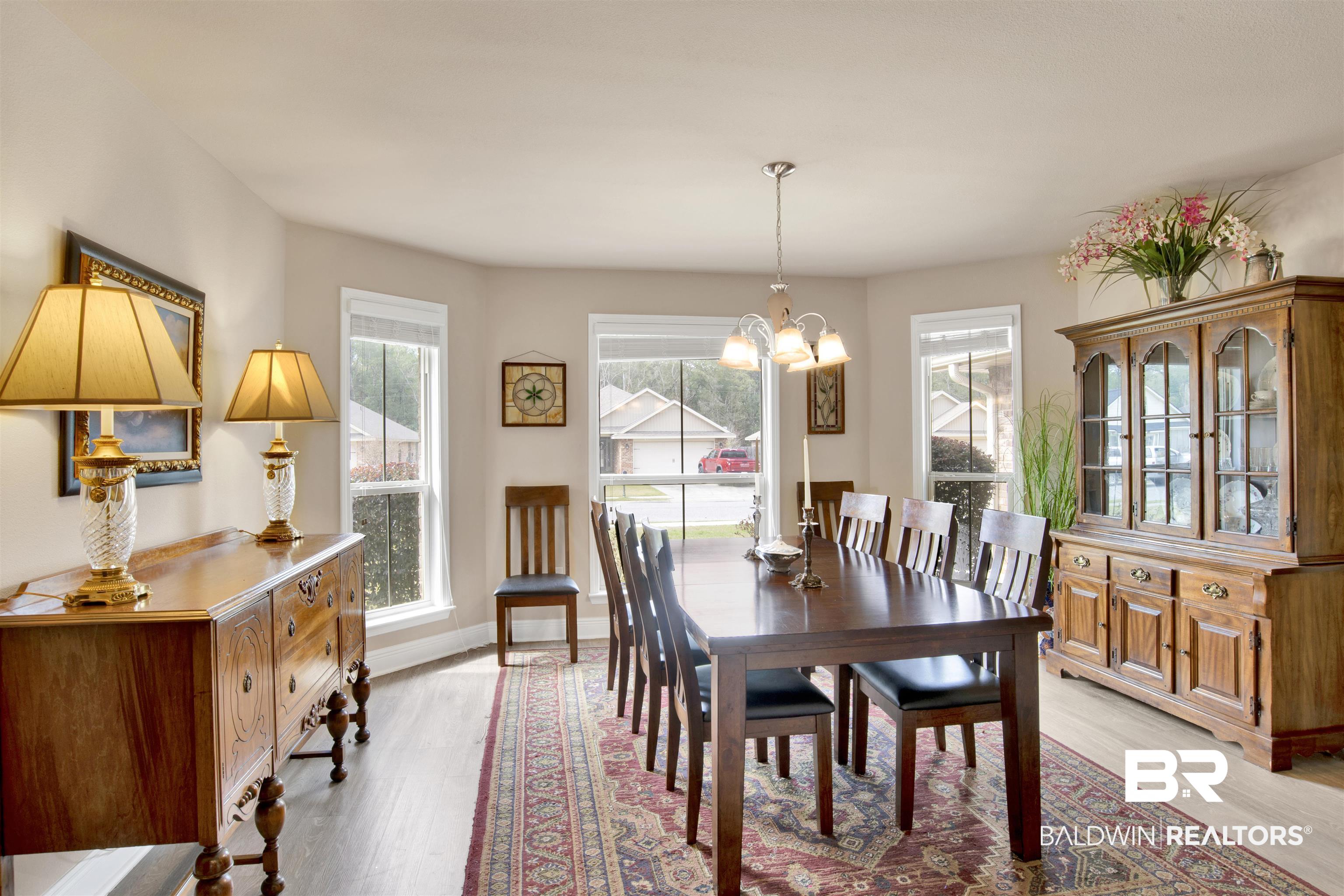 22056 Garland Loop Silverhill, AL 36576 - Photo 5 of 28 Dining room with baseboards, light wood-style floors, and a notable chandelier