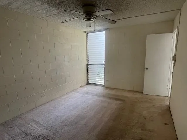 a view of a room with a ceiling fan and window