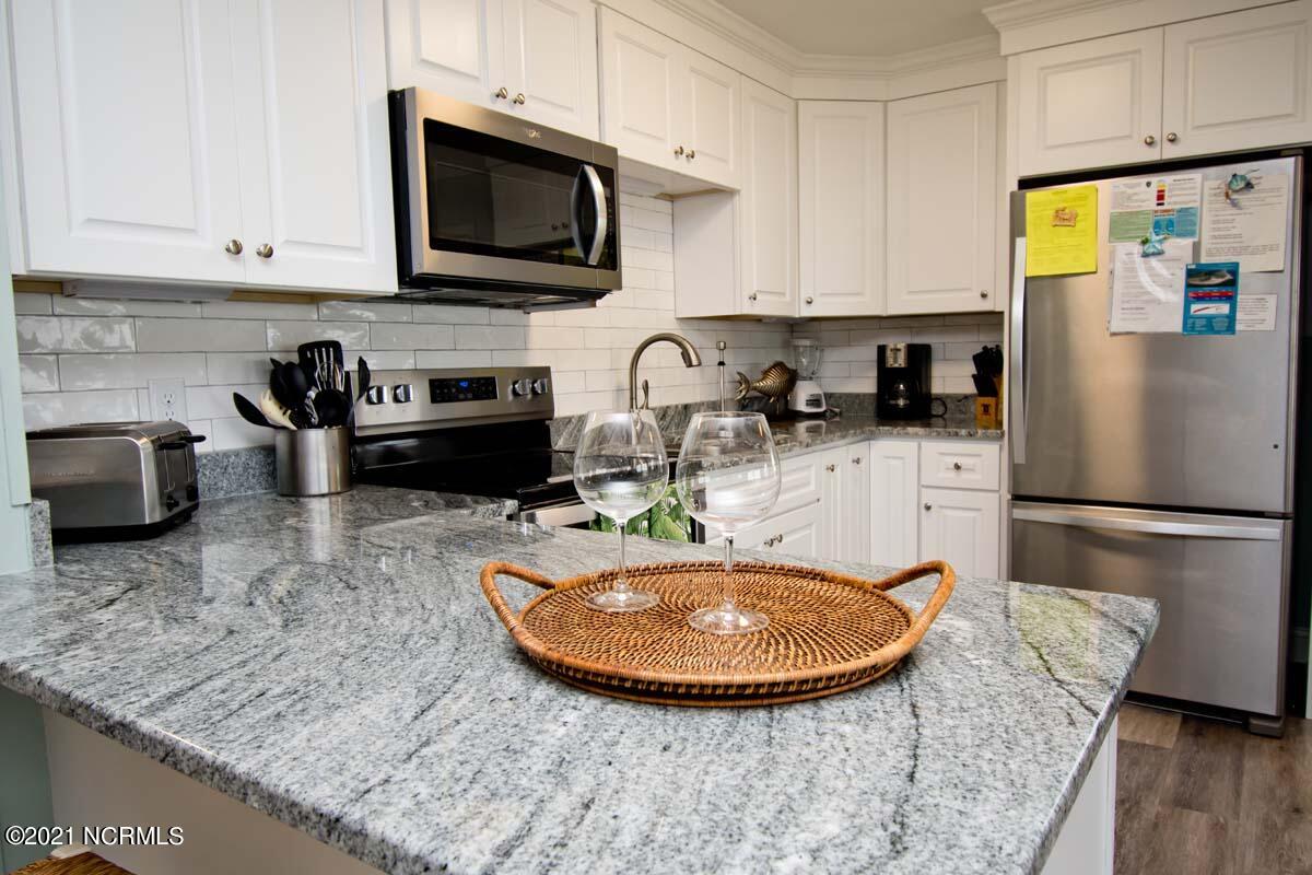 4105 Ocean Drive, Unit E & W Emerald Isle, NC 28594 - Photo 14 of 72 EastThis 8 bedroom duplex has undergone many great updates in the last couple of years to include: 2021-EAST SIDE- renovated kitchen with new cabinets, stainless appliances, granite counters, new lvp flooring on first level, and new granite in the lower level bath.