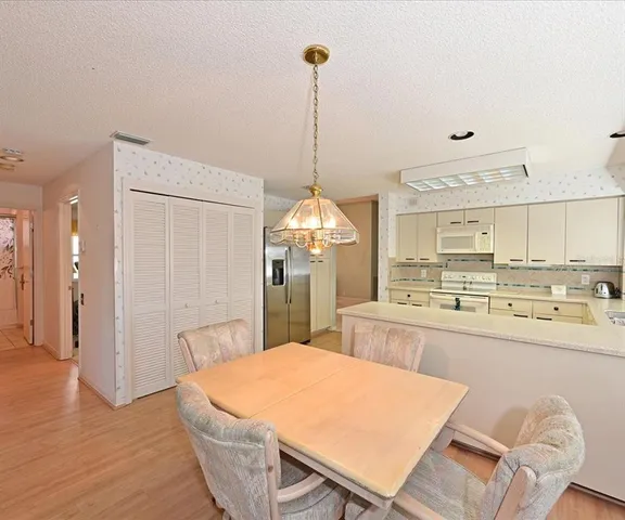 a kitchen with stainless steel appliances kitchen island granite countertop a refrigerator a stove a sink dishwasher with a dining table and chairs