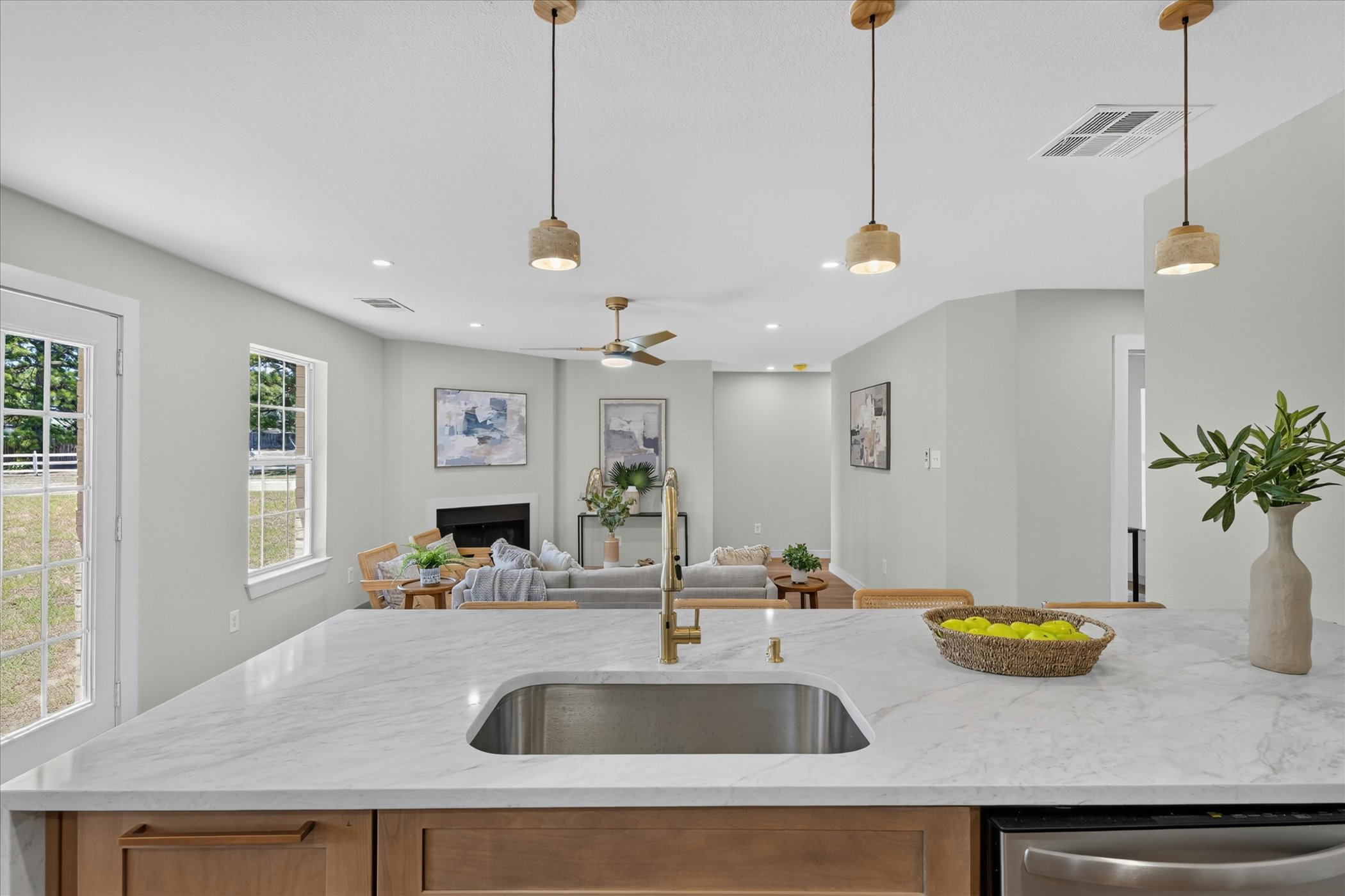 258 Pine View Loop Bastrop, TX 78602 - Photo 24 of 40 A well-appointed kitchen island with a sink overlooks an inviting living area, perfect for social gatherings.