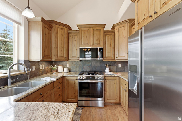 3026 Lower Saddleback Road Park City, UT 84098 - Photo 14 of 71 Kitchen with stainless steel appliances, plenty of natural light, vaulted ceiling, light stone countertops, and hanging light fixtures