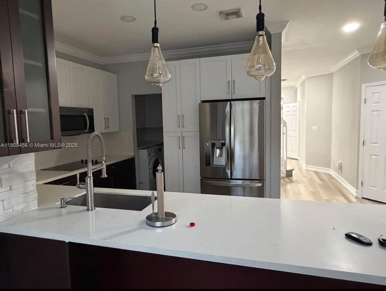 a kitchen with stainless steel appliances a sink and a refrigerator