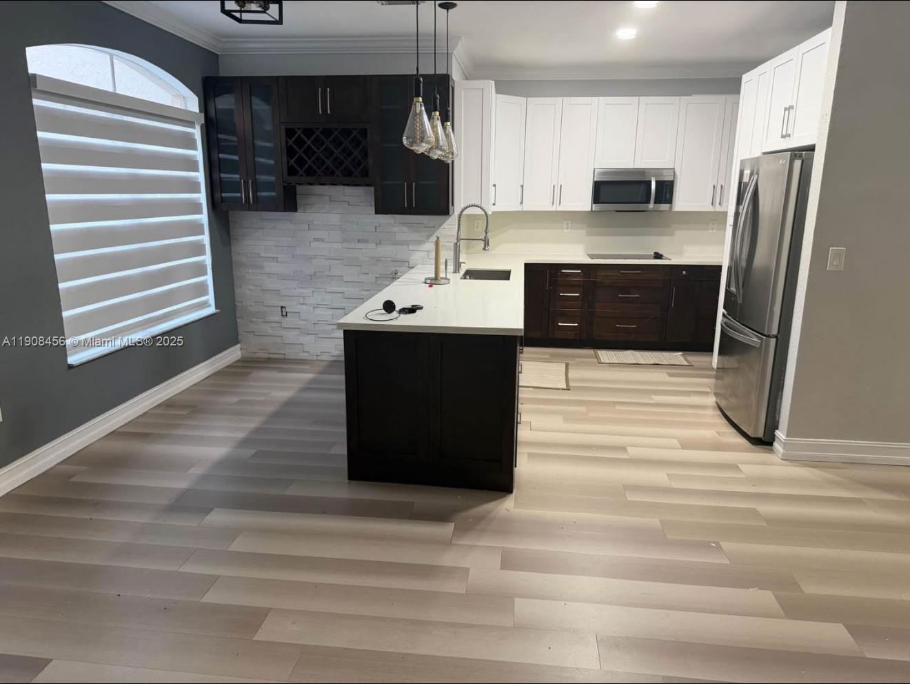 965 Southwest 153rd Path Miami, FL 33194 - Photo 2 of 27 a kitchen with kitchen island a sink stainless steel appliances and cabinets
