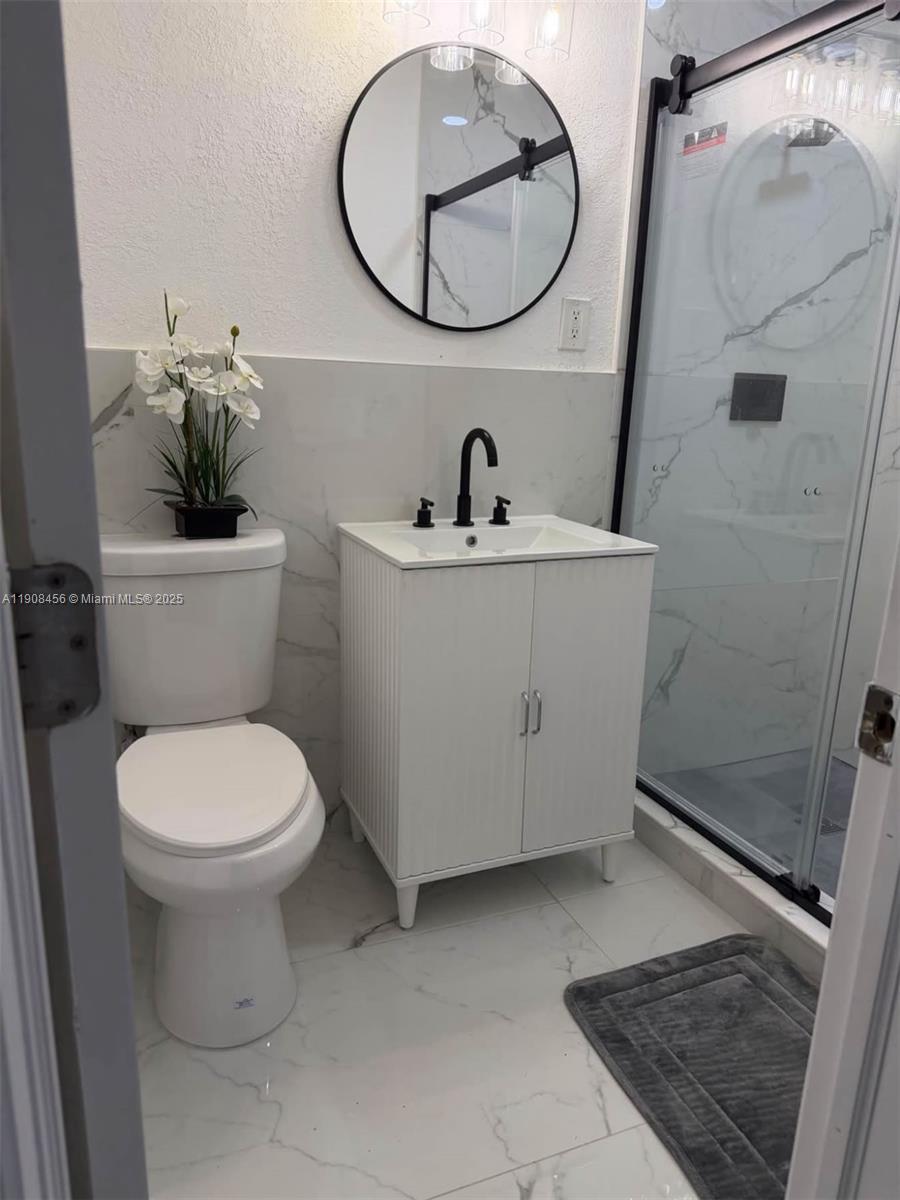 965 Southwest 153rd Path Miami, FL 33194 - Photo 5 of 27 a bathroom with a toilet sink and mirror