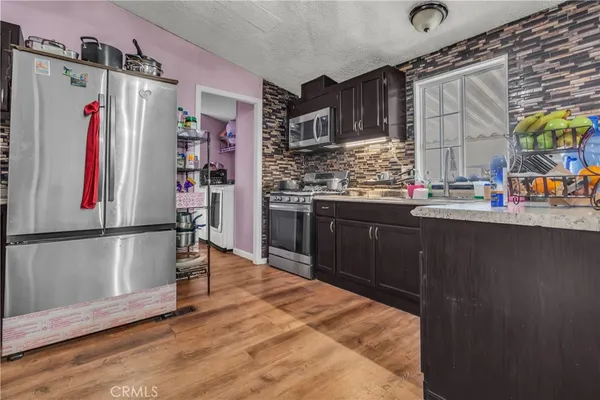a kitchen with stainless steel appliances granite countertop a refrigerator and a sink