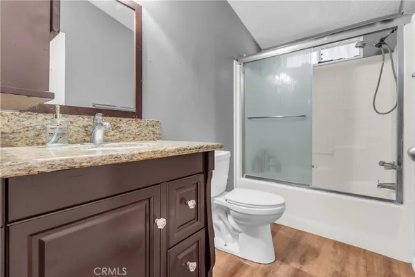 a bathroom with a granite countertop sink toilet and shower