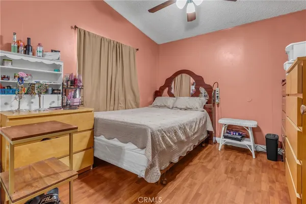a bedroom with a bed and a flat tv screen on dresser