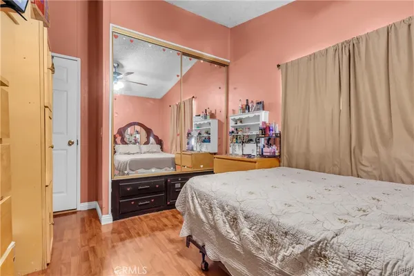 a bedroom with a bed and a large mirror on the dresser