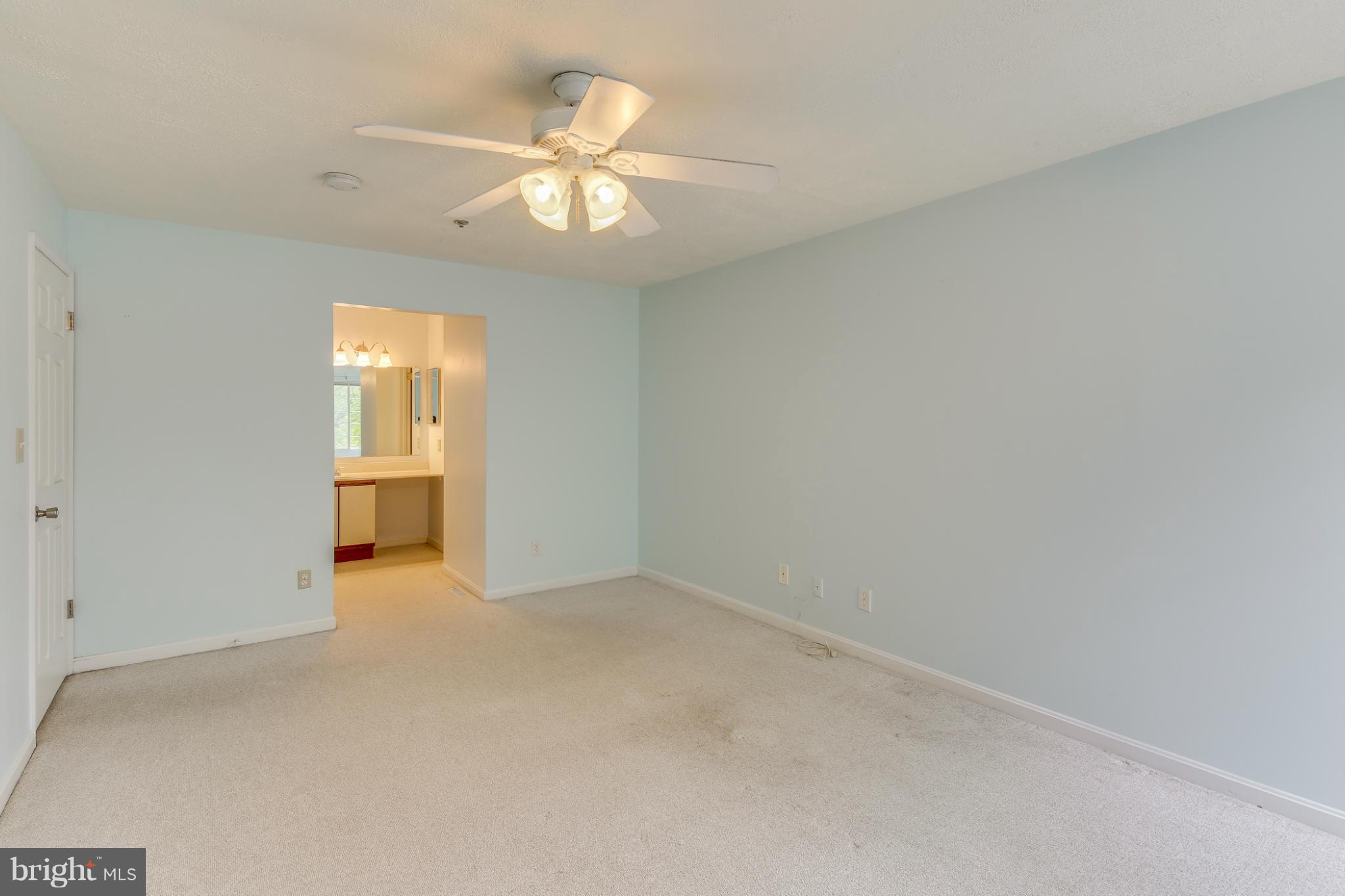4906 Columbia Road, Unit 7 Columbia, MD 21044 - Photo 22 of 26 an empty room with a chandelier fan and windows