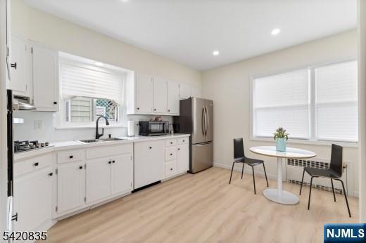 39 Hurden Street Hillside, NJ 07205 - Photo 7 of 20 a kitchen with stainless steel appliances granite countertop a stove a sink a refrigerator with white cabinets and wooden floor