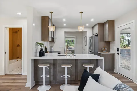 a kitchen with kitchen island a sink stove and refrigerator with wooden floor