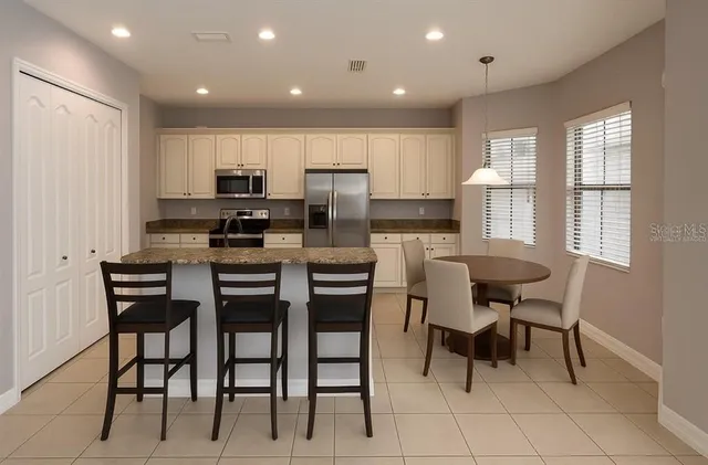 an empty room with chandelier fan and windows