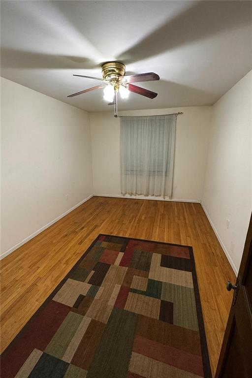 9801 Shore Road, Unit 2Q Brooklyn, NY 11209 - Photo 5 of 9 a view of an empty room with wooden floor and fan