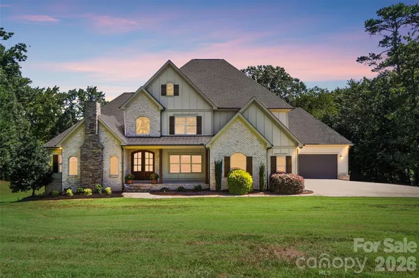 a front view of a house with a garden and yard
