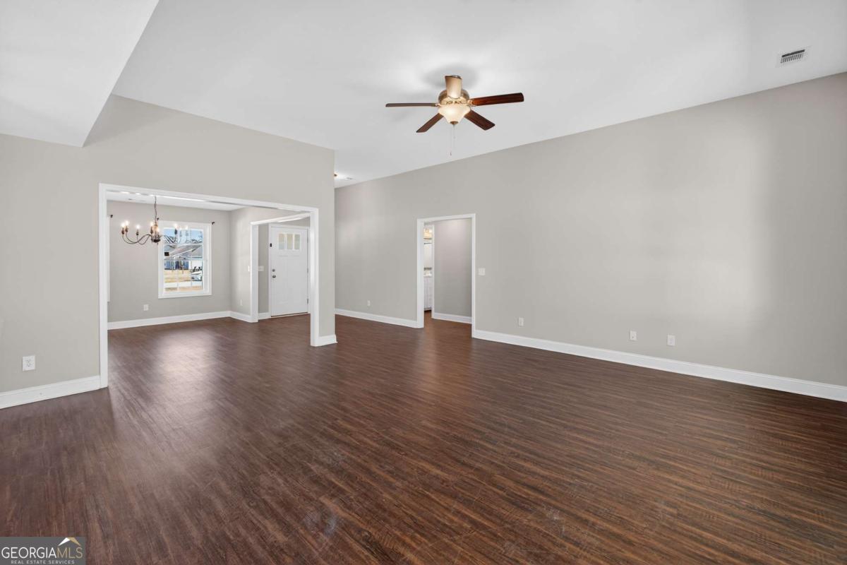303 Tallulah Bend Ellabell, GA 31308 - Photo 13 of 48 a view of an empty room with a window and wooden floor