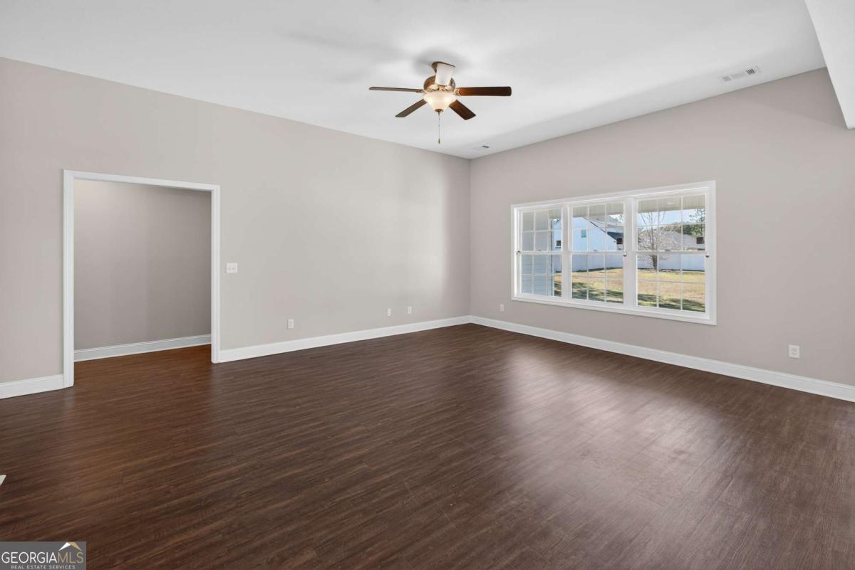 303 Tallulah Bend Ellabell, GA 31308 - Photo 15 of 48 a view of an empty room with wooden floor and a ceiling fan