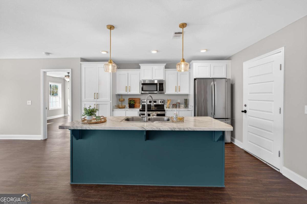 303 Tallulah Bend Ellabell, GA 31308 - Photo 16 of 48 a kitchen with kitchen island stainless steel appliances a sink a center island and wooden floor