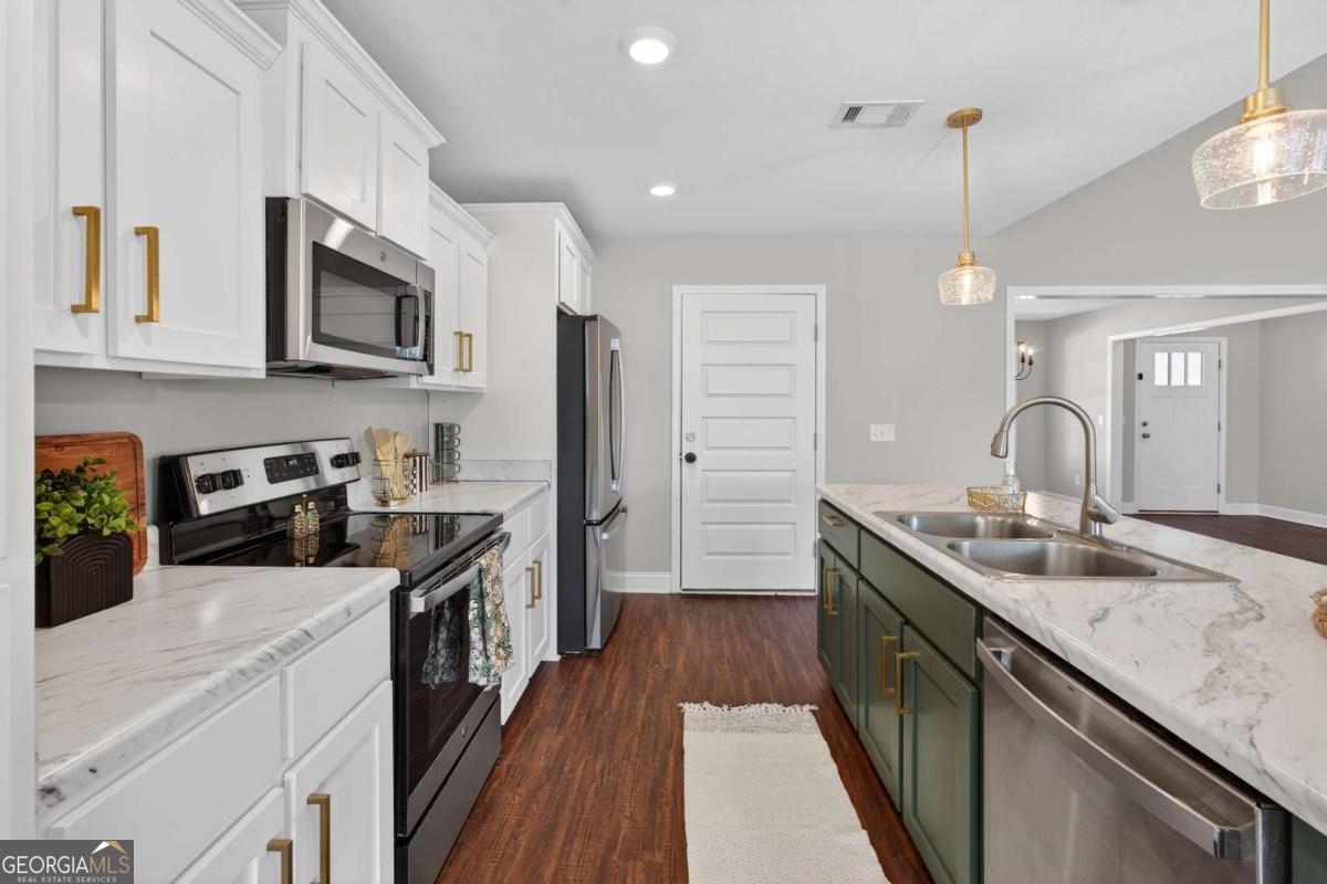 303 Tallulah Bend Ellabell, GA 31308 - Photo 19 of 48 a kitchen with stainless steel appliances granite countertop a sink stove and refrigerator