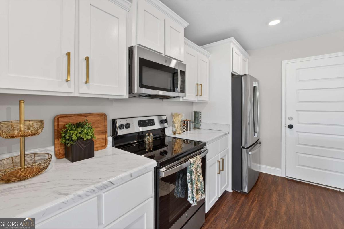 303 Tallulah Bend Ellabell, GA 31308 - Photo 22 of 48 a kitchen with stainless steel appliances white cabinets and a stove top oven