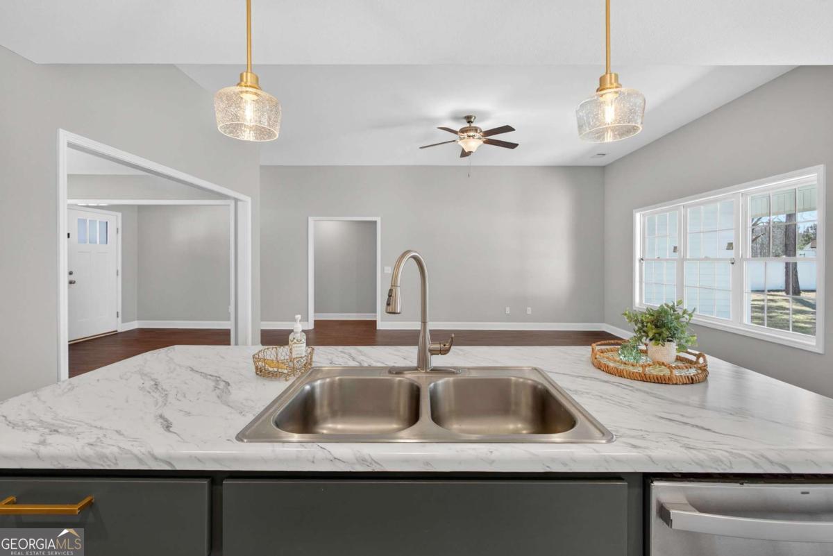 303 Tallulah Bend Ellabell, GA 31308 - Photo 23 of 48 a kitchen with kitchen island granite countertop a sink a counter space and cabinets