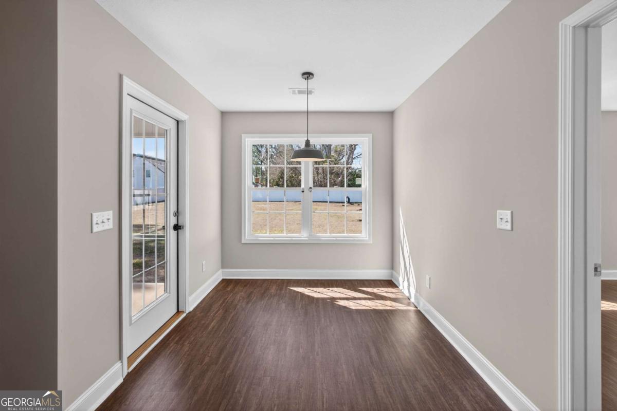303 Tallulah Bend Ellabell, GA 31308 - Photo 24 of 48 a view of an empty room with wooden floor and a window