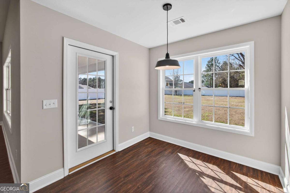 303 Tallulah Bend Ellabell, GA 31308 - Photo 25 of 48 a view of an empty room with a window and wooden floor