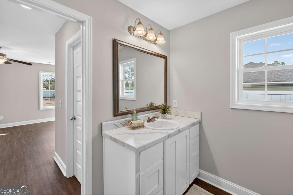 303 Tallulah Bend Ellabell, GA 31308 - Photo 31 of 48 a bathroom with a sink a vanity and a mirror