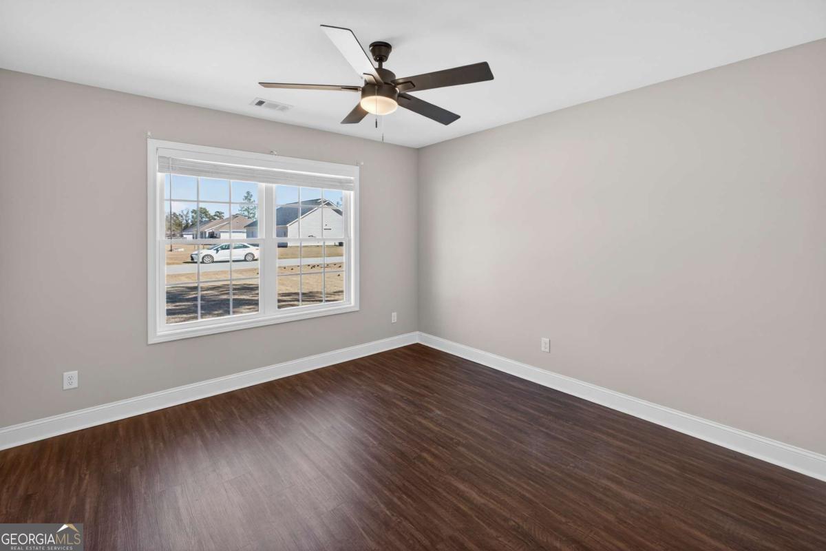 303 Tallulah Bend Ellabell, GA 31308 - Photo 33 of 48 an empty room with wooden floor window and ceiling fan
