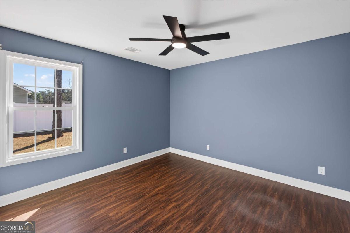 303 Tallulah Bend Ellabell, GA 31308 - Photo 35 of 48 a view of an empty room with a window and wooden floor