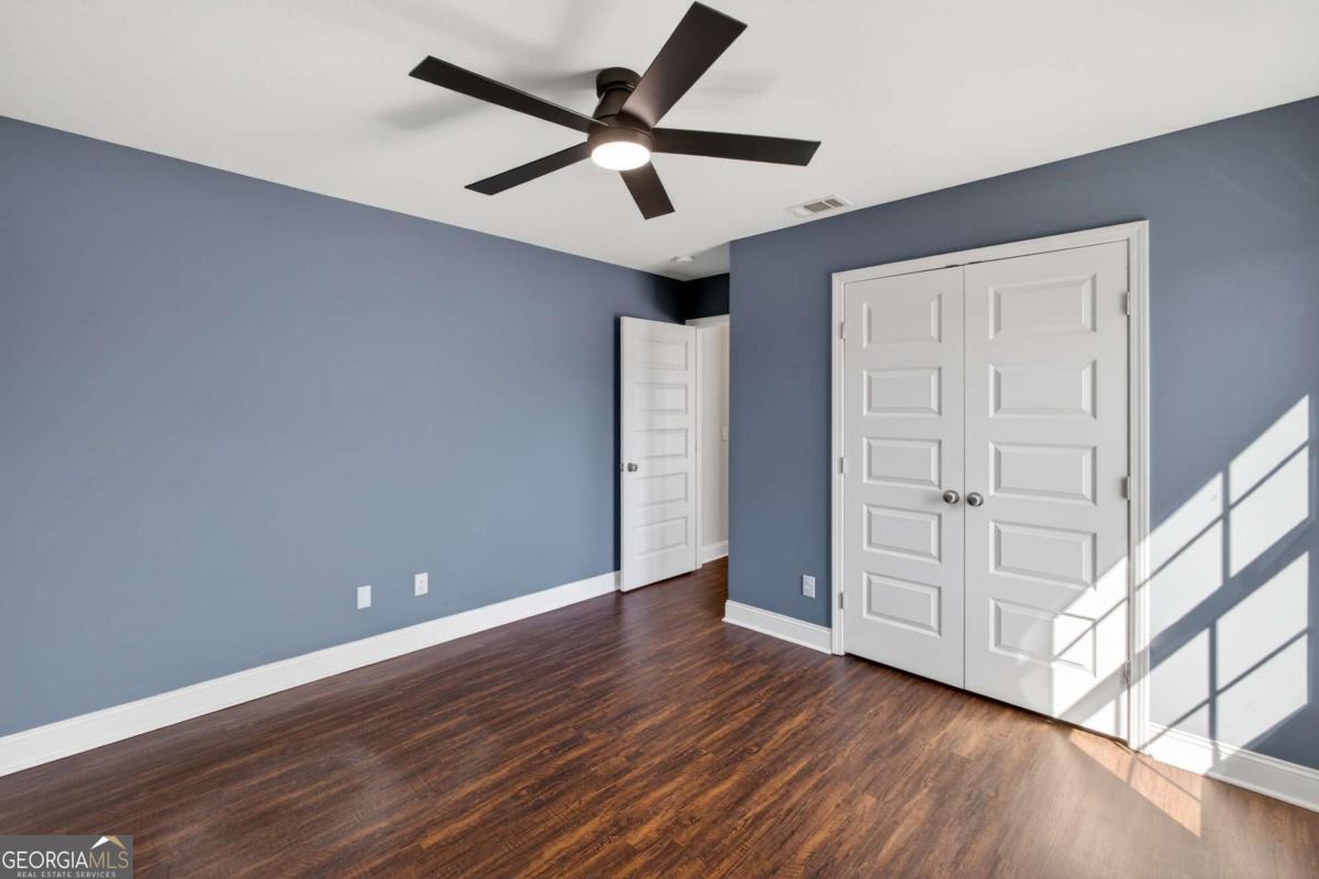 303 Tallulah Bend Ellabell, GA 31308 - Photo 36 of 48 an empty room with wooden floor a ceiling fan and windows
